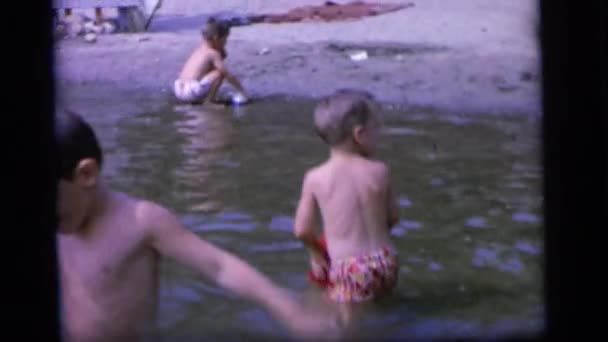 Мальчик льет воду в реку — стоковое видео
