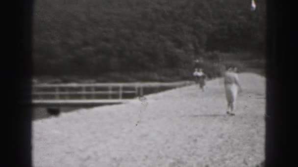 Люди, гуляющие возле реки — стоковое видео