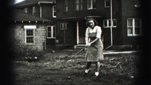 Женщина играет в гольф в саду — стоковое видео