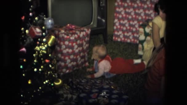 Familia sentada cerca del árbol de Navidad — Vídeos de Stock