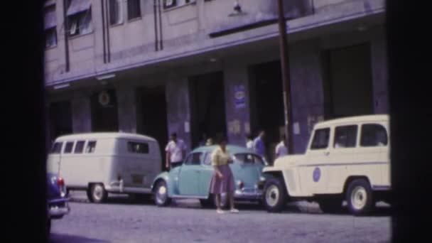 Una calle con coches viejos y gente hermosa — Vídeos de Stock