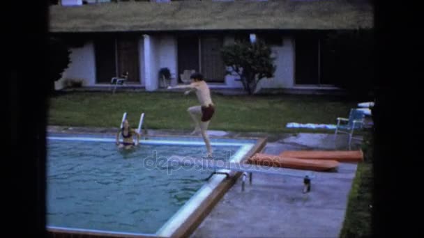 Boy jumping doing flip off of swimming pool — Stock Video
