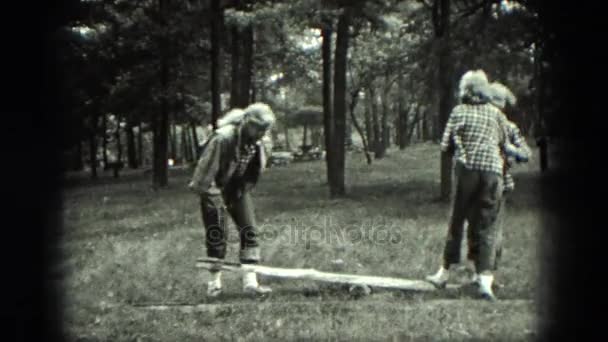 Un grupo de niñas juegan en y alrededor de la limpieza de una zona boscosa . — Vídeos de Stock