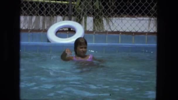 Chica salpicando y jugando en la piscina — Vídeos de Stock