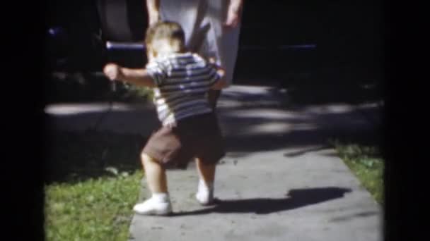 Маленький мальчик ходит по тротуару — стоковое видео
