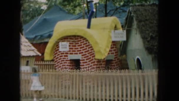 ミニチュアの家公園でピークの女の子 — ストック動画