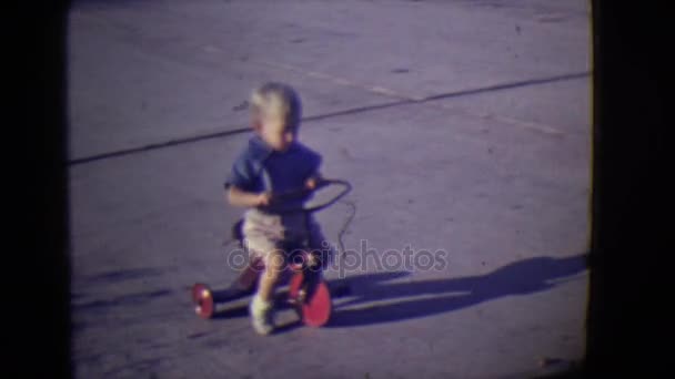 Kind driewieler rond gladder oppervlak asfalt duwen — Stockvideo