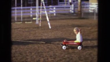 Çim biçme makinesi üzerinde adamla çocuk römork üzerinde