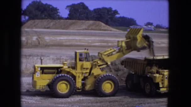 Erdbewegungsmaschine schüttet Erde in die Fahrerkabine eines Lastwagens — Stockvideo