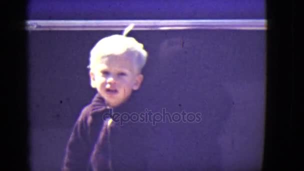 Un niño pequeño se ve posando — Vídeos de Stock