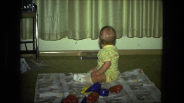 Ребенок, сидящий на одеяле в середине комнаты — стоковое видео