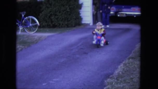 Boy ridning trehjuling på gårdsplanen — Stockvideo