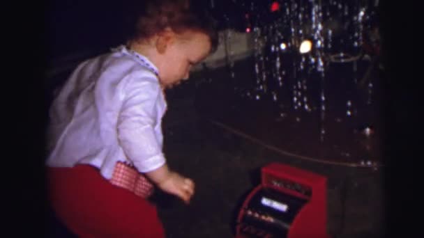 Un árbol de navidad con un niño abriendo regalos — Vídeos de Stock