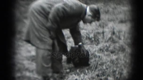 Mann i kåpe klapper hund – stockvideo