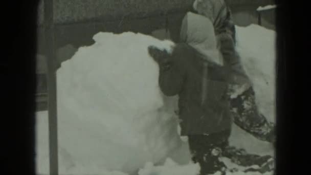 Niños moldeando muñeco de nieve — Vídeos de Stock