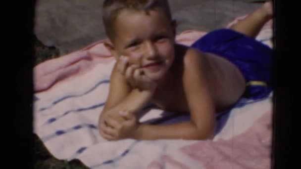 ビーチに blunket で横たわっている少年 — ストック動画
