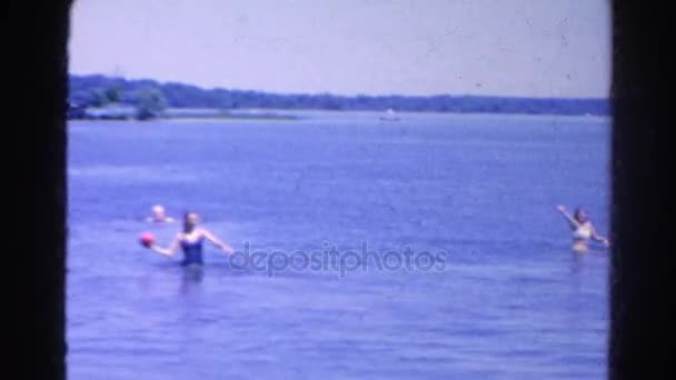 Οικογένεια που ρίχνει μια μπάλα σε μια λίμνη κατά τη διάρκεια του καλοκαιριού — Αρχείο Βίντεο