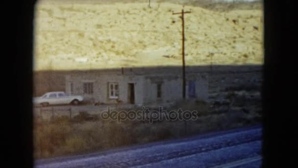 Een eenzaam huis in de bergen langs de weg — Stockvideo