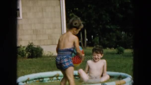 膨脹可能なプールにトランクを泳ぐ少年ジャンプします。 — ストック動画