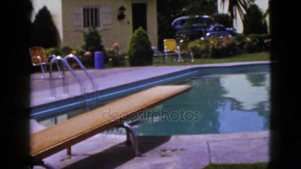 Backyard pool and woman on beach chair — Stock Video