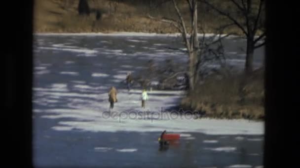 Рыбаки идут по замерзшей реке — стоковое видео
