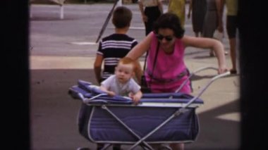 bir kadın çocuğunu bebek arabası içinde tutmak için mücadele