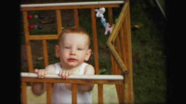 Bebé jugando en cuna de madera — Vídeo de stock