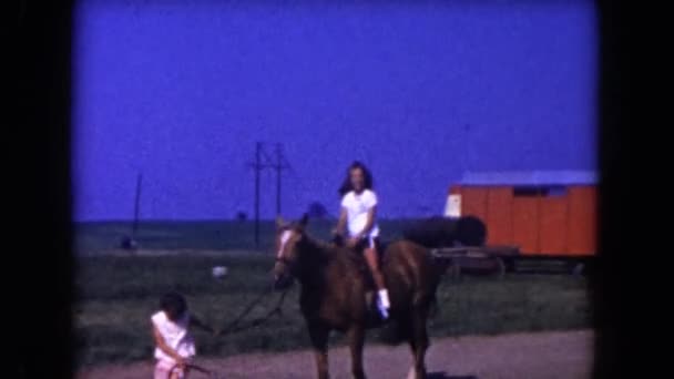 Girl on a horse while another girl is pulling the horse — Stock Video