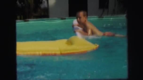 Chicos y una chica jugar felizmente en un patio trasero piscina — Vídeos de Stock