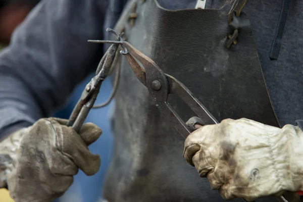 Blacksmith at work in gloves with pliers — Φωτογραφία Αρχείου
