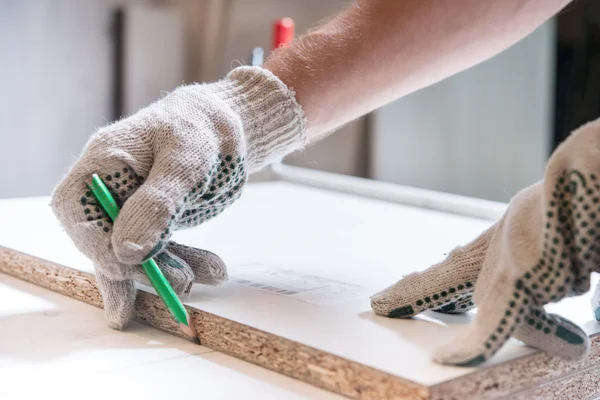 Master carpenter draws pencil on board