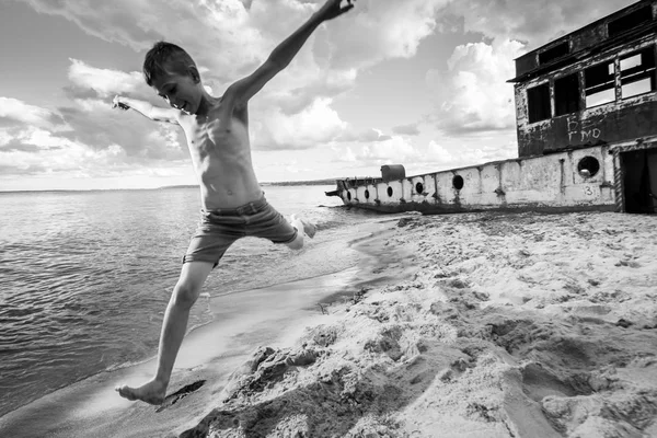 Мальчик шорты счастливые прыжки и флипы на пляже летом — стоковое фото