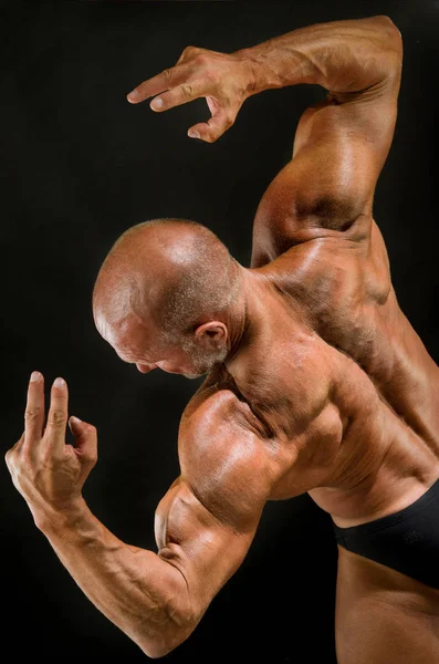 Male athlete bodybuilder demonstrates muscles of the back — Stock Photo, Image