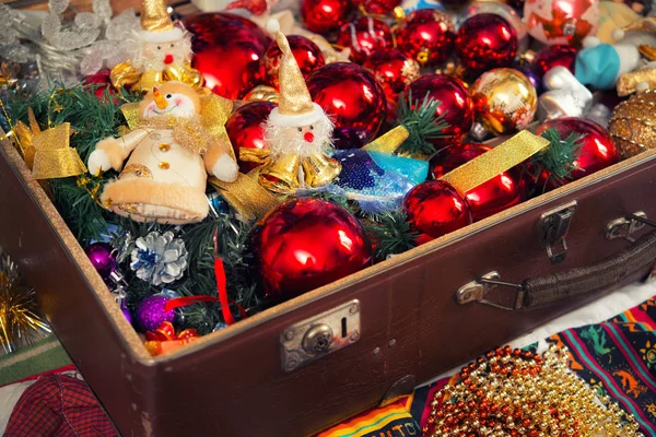 Bolas de Navidad y muñeco de nieve juguete en maleta vieja — Foto de Stock
