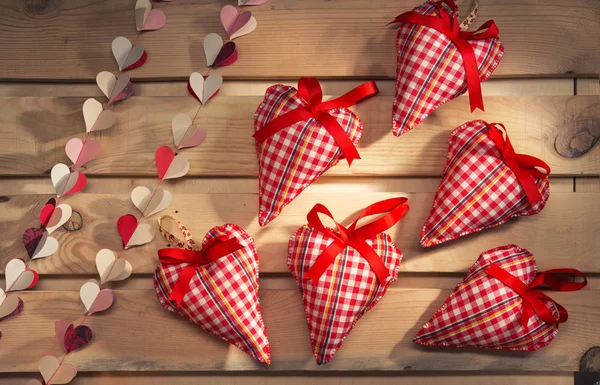 Beaucoup de cœurs cousus à partir de tissu à carreaux rouges sur la planche, un symbole d'amour — Photo