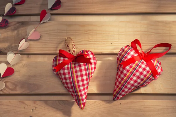 Deux cœurs cousus de tissu à carreaux rouges sur la planche, un symbole d'amour — Photo