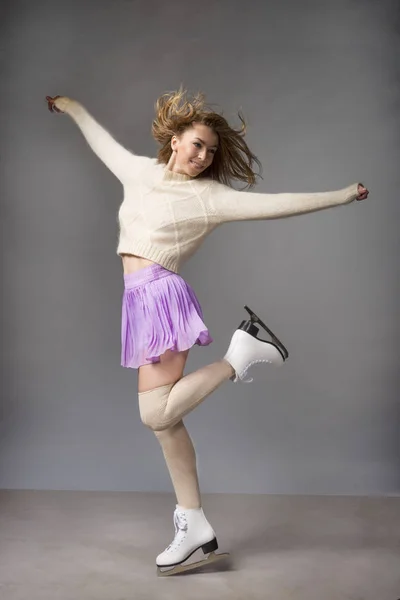 Rolig flicka i en kjol skridskor på is — Stockfoto