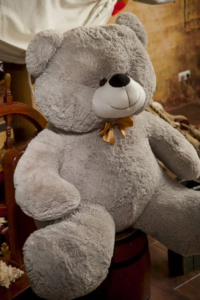 Urso de pelúcia de brinquedo cinza sentado em um barril perto de um veleiro — Fotografia de Stock