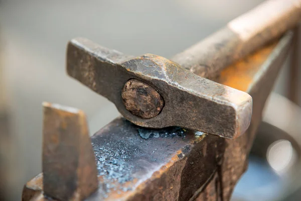 Martillo de herrero de metal en un pequeño yunque — Foto de Stock