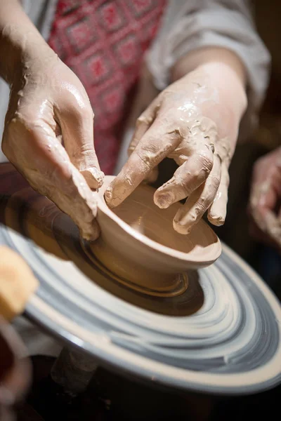Bambino impara a scolpire una piastra in ceramica sulla ruota di un vasaio. Primo piano della mano di un bambino . — Foto Stock