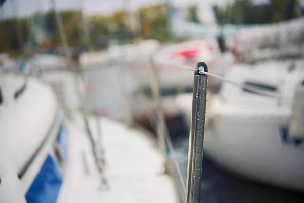 Arrière-plan flou. Yachts avec voiles pliées sur le rivage près de la jetée. Automne . — Photo