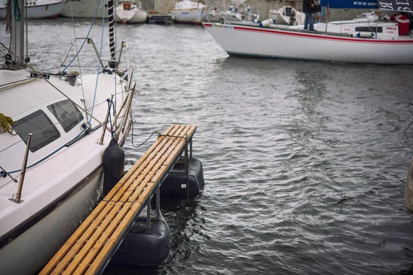 Yachten mit gefalteten Segeln am Ufer in der Nähe der Seebrücke. Herbst. — Stockfoto