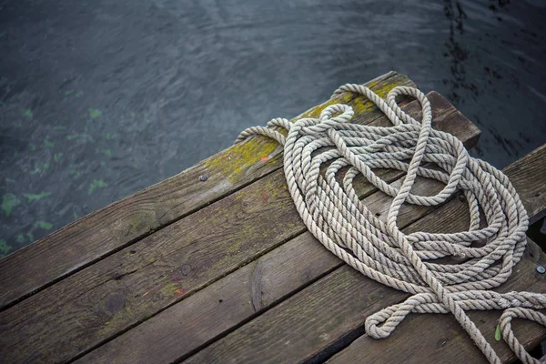 Old ship rope on a wooden obsolete pier — Stock Photo, Image