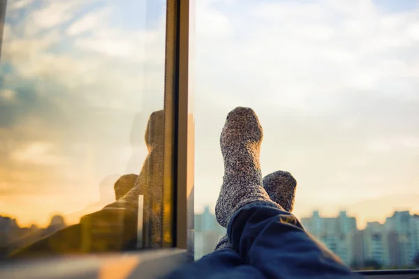 Men\'s feet in socks on relaxation window