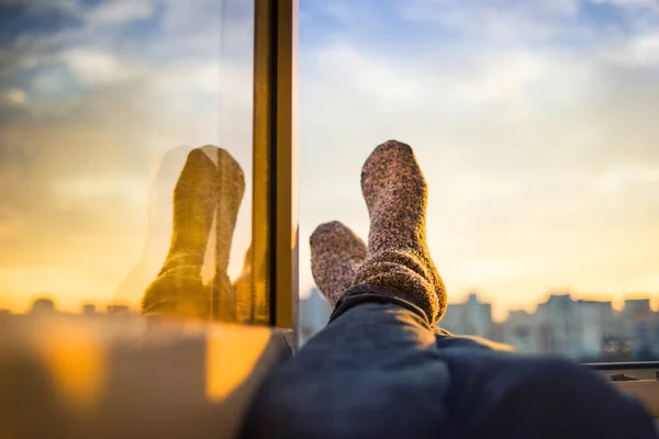 Men\'s feet in socks on relaxation window