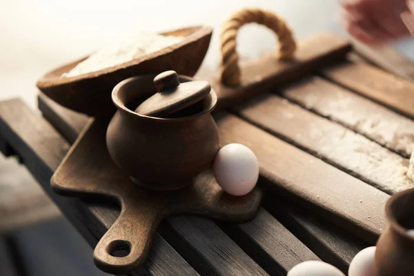 Meel, eieren en pot op een houten tafel. — Stockfoto