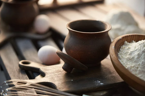 Farine, œufs et pot sur une table en bois . — Photo