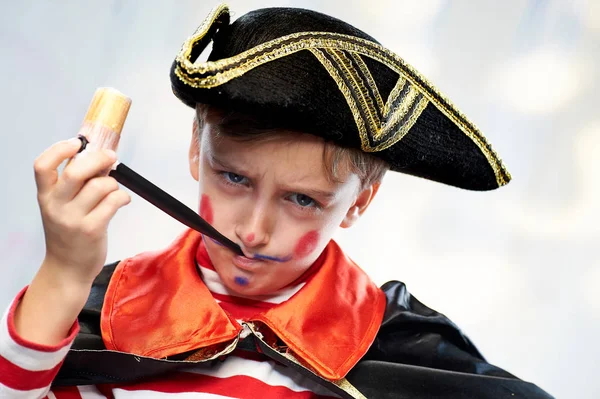 Niño con un traje de marinero pirata fuma una pipa de juguete . — Foto de Stock