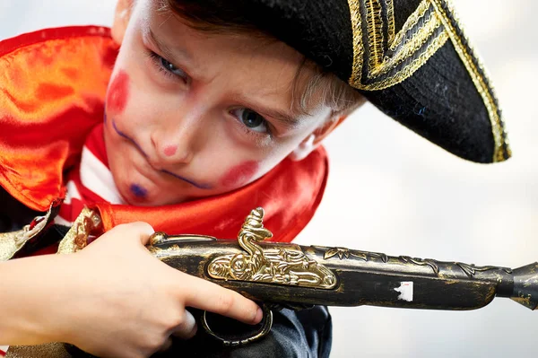 Malý chlapec oblečený jako pirátský námořník, se starou pistolí — Stock fotografie