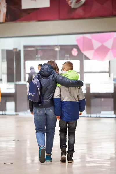 Mamá y su hijo en chaquetas están hablando en el centro comercial . — Foto de Stock